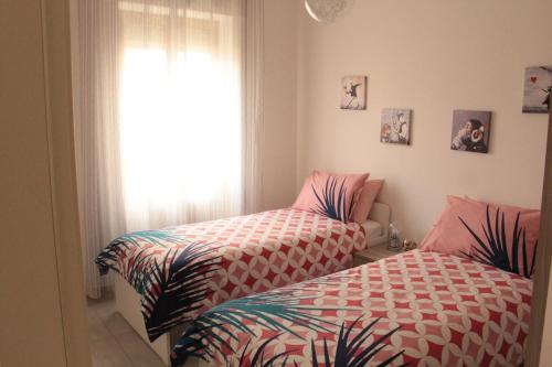 two twin beds in a room with a window at Alcalù in San Vincenzo