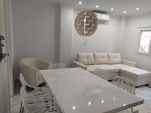 - un salon avec une table et des chaises blanches dans l'établissement Beach Dream Apartment, à La Mata