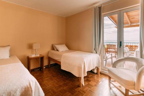 Un dormitorio con dos camas y un balcón. en Atlantic View Penthouse, en Funchal