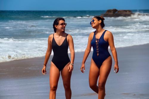 two women in bathing suits walking on the beach at El Mirador de Vichayito in Vichayito
