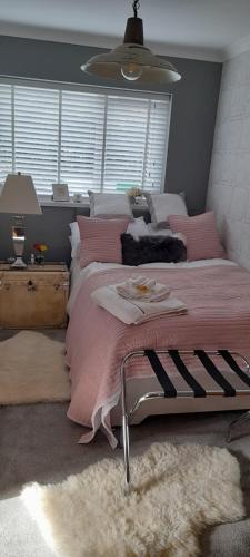 a bedroom with a large bed with a pink blanket at The lodge in Blackwood