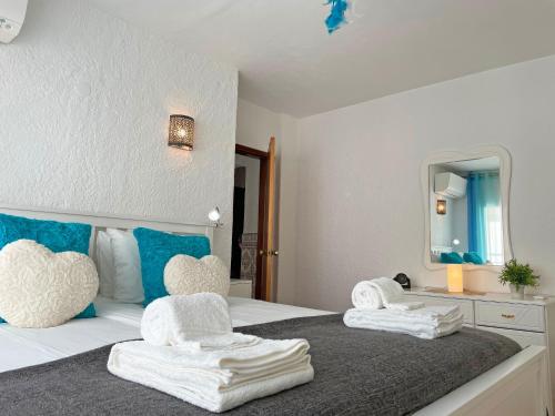 1 dormitorio con 1 cama con toallas en Algarve Sol Beach House, en Quarteira