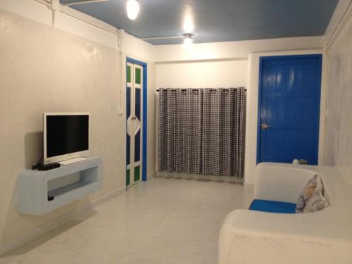a living room with a tv on a wall at De Sea Almond in Chumphon