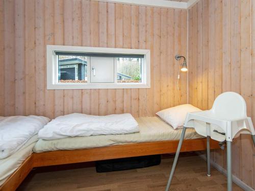 LoddenhøjにあるThree-Bedroom Holiday home in Aabenraa 3の窓と椅子が備わる客室のベッド1台分です。
