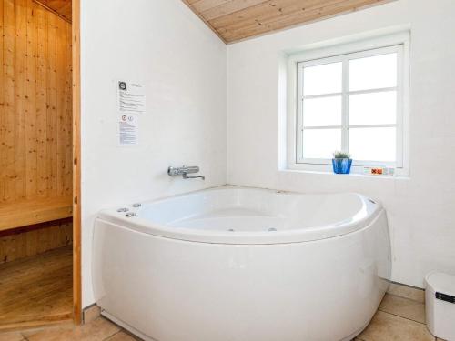 a white bath tub in a bathroom with a window at Four-Bedroom Holiday home in Ulfborg 9 in Øby