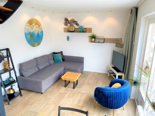 a living room with a couch and a tv at Vakantiehuis Boulevard in Egmond aan Zee