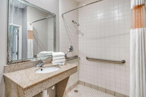 uma casa de banho com um lavatório e um chuveiro em Motel 6-Houston, TX - Spring em Houston