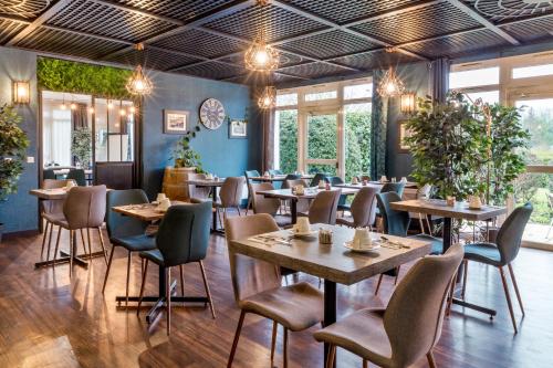 a restaurant with tables and chairs and windows at Sure Hotel by Best Western Calais Coquelles Tunnel s/ Manche in Coquelles