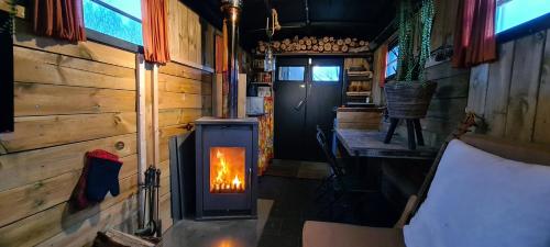 a wood burning stove in a room with a door at Trekkershut in Middelburg