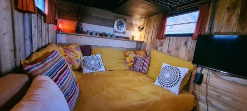 a living room with a yellow couch in a trailer at Trekkershut in Middelburg
