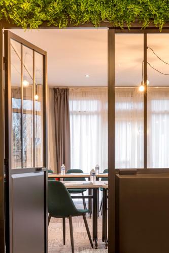 a dining room with a table and chairs at Sure Hotel by Best Western Calais Coquelles Tunnel s/ Manche in Coquelles