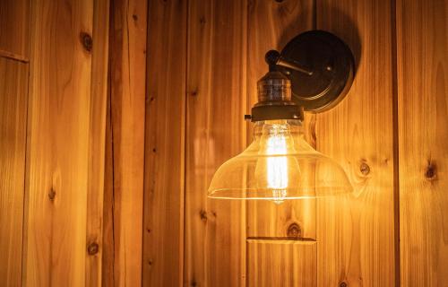 a light hanging on a wooden wall at Boulder Mountain Resort in Revelstoke