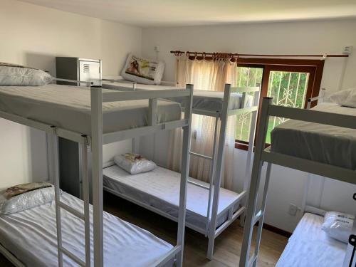 a room with three bunk beds and a window at Lampião Hostel in Florianópolis