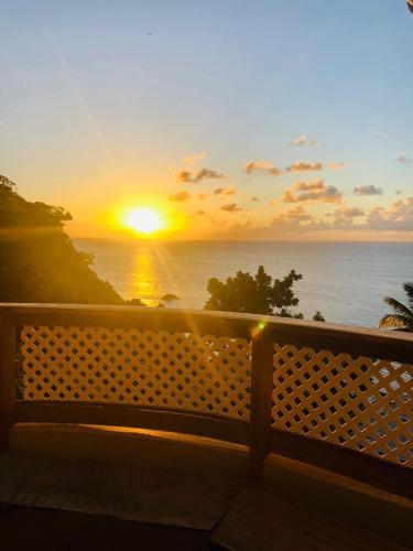 a sunset over the ocean from a balcony at Castara Inn in Castara
