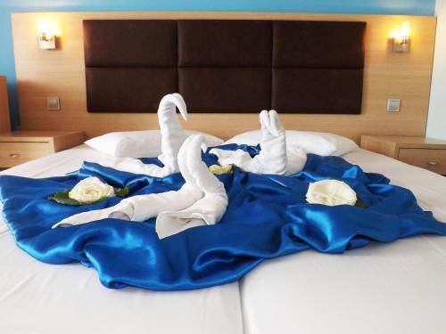 two white swans are laying on a bed at Leonidas Hotel & Studios in Kos