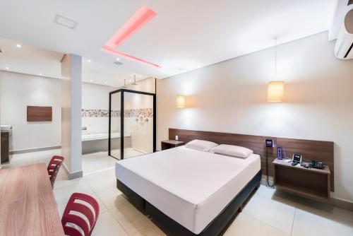 - une chambre avec un lit, une table et des chaises dans l'établissement Plaza Motel, à Sorocaba