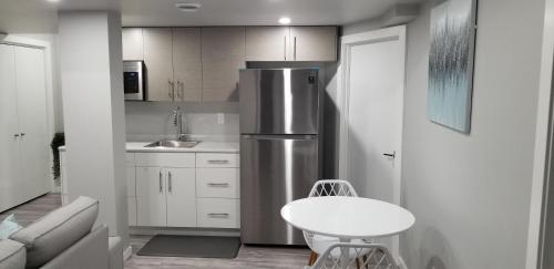 a kitchen with a stainless steel refrigerator and a table at Luxurious 2 bedroom basement suite in Winnipeg