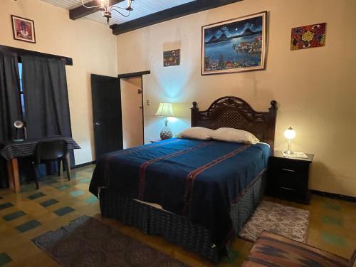 a bedroom with a bed and a chair and a table at Villas JABEL TINAMIT in Panajachel