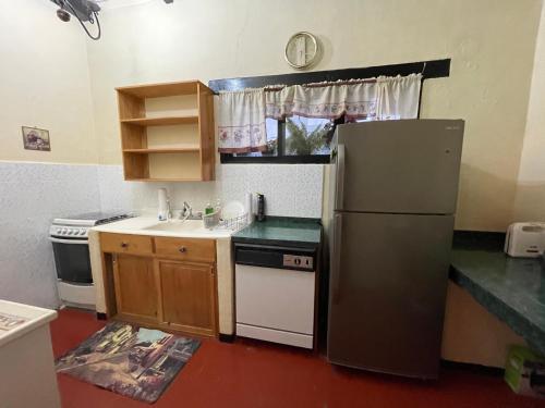 a small kitchen with a refrigerator and a sink at Villas JABEL TINAMIT in Panajachel