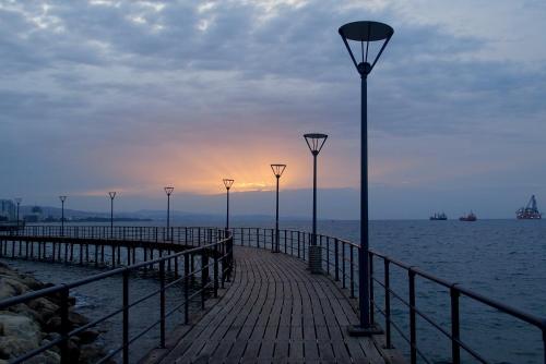 a row of lights on a pier next to the water at Artemis Boutique Apartment 2 in Limassol