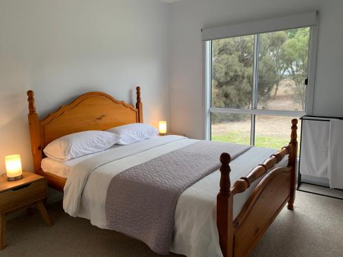 Un dormitorio con una cama y una ventana grande. en Kangaroo Island Cabins, en Kingscote
