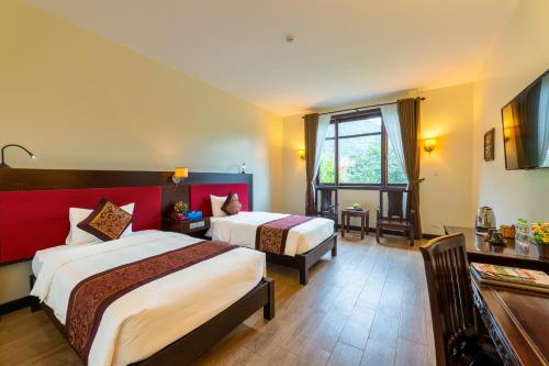 a hotel room with two beds and a window at Khách xá Bái Đính in Ninh Binh