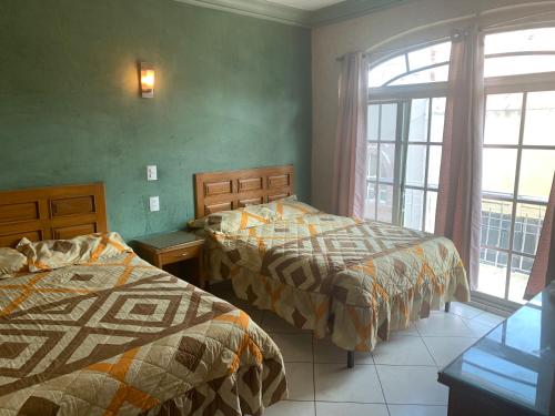 En eller flere senger på et rom på Hotel Hacienda Salvador