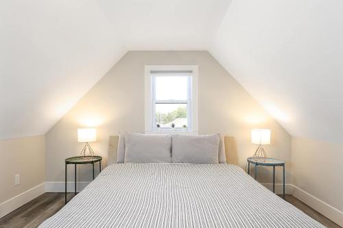 a bedroom with a white bed with two lamps at Modern Duplex Downtown AC Walkable in Traverse City