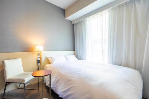 a hotel room with a bed and two lamps at Hotel Wing International Premium Shibuya in Tokyo