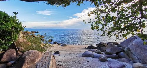 a beach with a bunch of rocks and the ocean at Tao Thong Villa 2 in Ko Tao