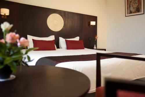 a hotel room with two beds with red pillows at Seabel Alhambra Beach Golf & Spa in Port El Kantaoui