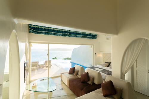 a bedroom with a bed and a view of the ocean at Yuki Suite Kourijima in Nakijin