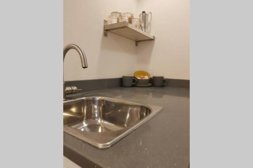a kitchen counter with a stainless steel sink at Private annex to Victorian villa, with kitchen and Free parking in Todmorden
