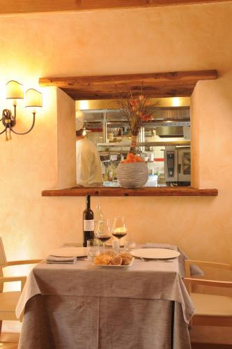 a table with wine glasses and a chef in a kitchen at Hotel Astra in Livigno