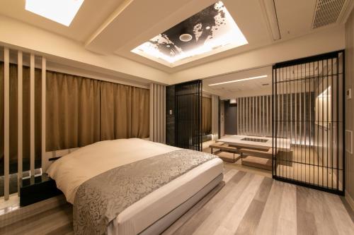 a bedroom with a large bed and a skylight at Hotel KARUTA 赤坂 in Tokyo
