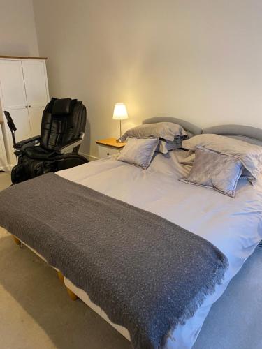 a bedroom with a large bed and a chair at Chichester Luxury One Bed Apartment in Chichester