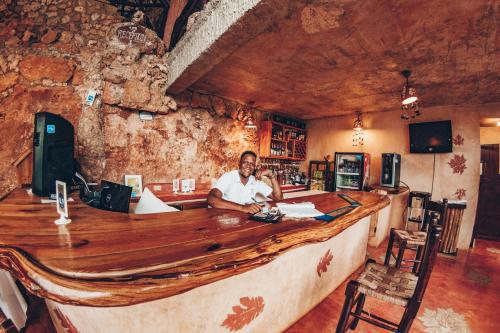 a man sitting at a bar in a restaurant at Altos de Caño Hondo in Los Guineos Perdidos