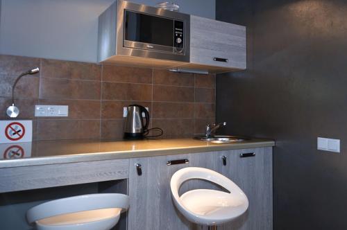 a bathroom with a sink and a toilet and a microwave at Partner Guest House Khreschatyk in Kyiv