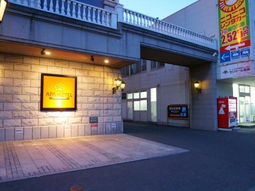 a building with a yellow sign on the side of it at APA Hotel Honhachinohe in Hachinohe