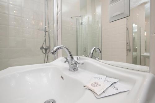 a white bathroom with a sink and a mirror at Partner Guest House Khreschatyk in Kyiv
