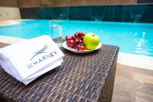 a plate of fruit on a table next to a pool at Wharney Hotel in Hong Kong