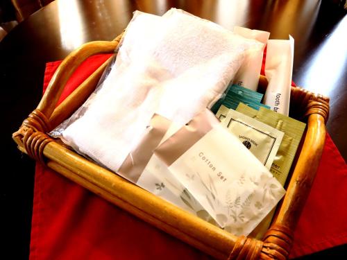 a wicker basket filled with towels and books on a table at Rantanrirun ランタンリルン in Hakuba