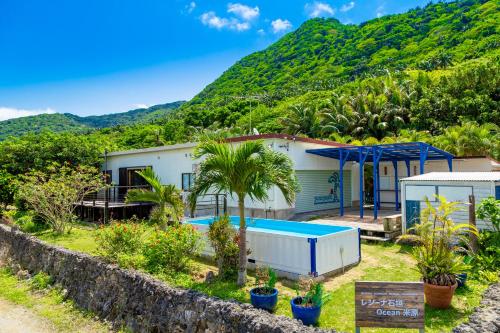 a house with a swimming pool in front of a mountain at Regina Ishigaki Ocean Yonehara / Two-Bedroom Villa in Fukai