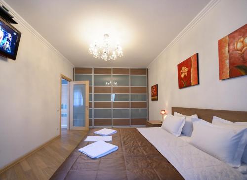 a bedroom with a large white bed and a chandelier at Partner Guest House Khreschatyk in Kyiv