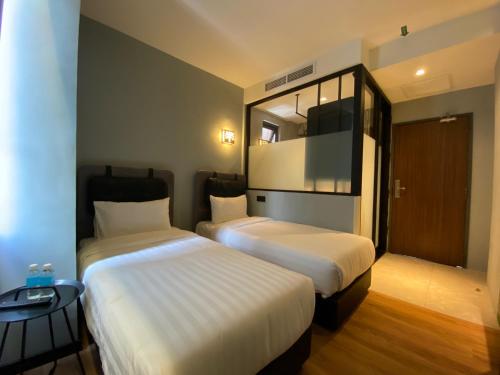 a hotel room with two beds and a mirror at The Seraya Hotel in Kota Kinabalu