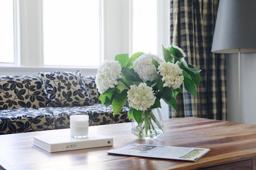a vase of flowers on a table in a living room at Hotel Collins in Melbourne