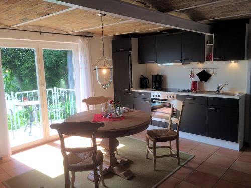 a kitchen with a wooden table and chairs and a kitchen with a window at Ferienhaus direkt am Schmalensee in Schmalensee