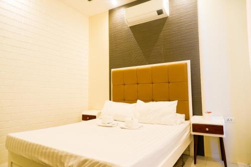 a bedroom with a bed with white sheets and white pillows at Armando's Garden Resort and Restaurant in Anao