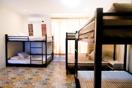 a room with three bunk beds and a window at Armando's Garden Resort and Restaurant in Anao
