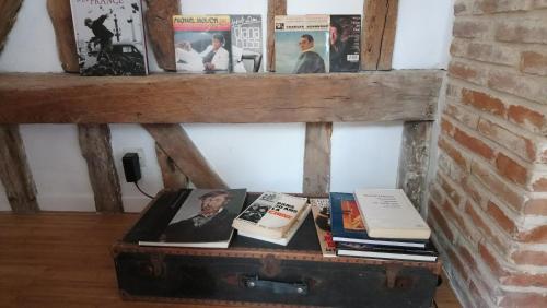 een koffer op de grond met boeken erop bij Loft de charme á 150m de la cathédrale in Beauvais